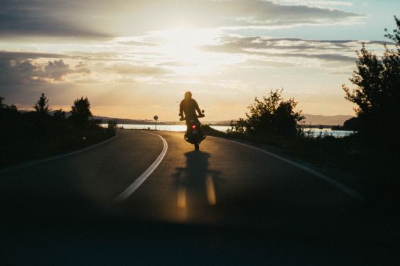 motorcycle riding around a curve at dusk