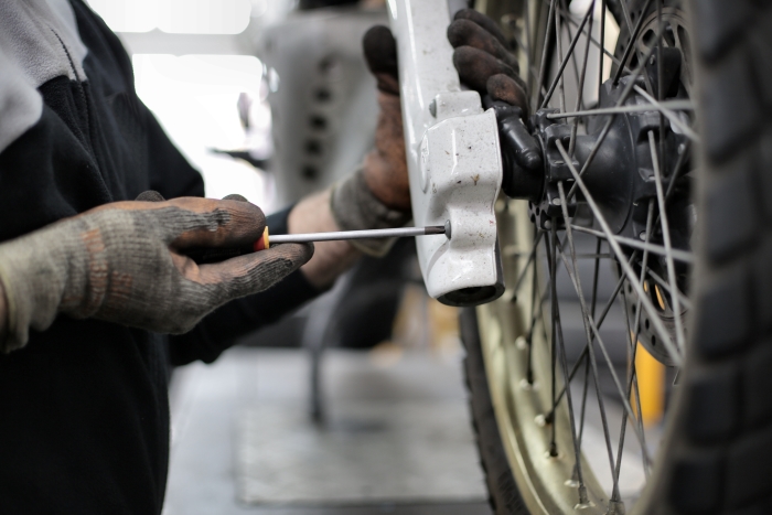 motorcycle mechanic fixing a motorcycle fork